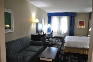a hotel room with a bed and a couch at Best Western Owego Inn in Owego