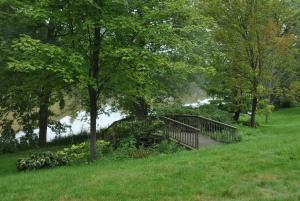 uma ponte de madeira sobre um rio num parque em Best Western Owego Inn em Owego