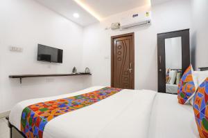 a bedroom with a bed and a tv on the wall at FabHotel Skycity in Haidar Sāhibgūda