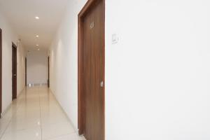 korytarz z drewnianymi drzwiami w budynku w obiekcie FabHotel Skycity w mieście Haidar Sāhibgūda