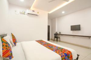 a bedroom with a bed and a flat screen tv at FabHotel Skycity in Haidar Sāhibgūda