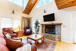 a living room with a fireplace and a tv at Up on Tanner Trail in Waynesville