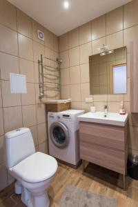 a bathroom with a toilet a sink and a washing machine at LeConte in Druskininkai