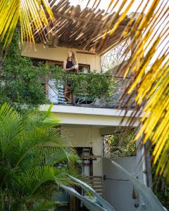 una mujer sentada en el balcón de un edificio en Casa Babi, en Vilanculos