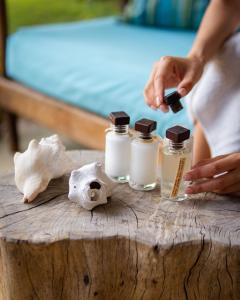 a person is putting paint in bottles on a table at Casa Babi in Vilanculos