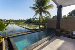 einen Pool mit Blick auf das Wasser in der Unterkunft Ikada Villa by Pramana Villas in Ubud