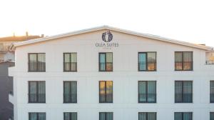 GemlikOlea Suites Otel的白色的建筑,上面有钟