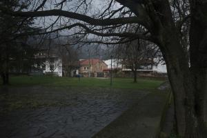 a park with a tree and a brick path at Posada la Estela de Barros in Los Corrales de Buelna