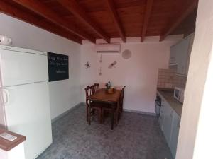 a kitchen with a table and chairs and a refrigerator at Tranquilo y Acogedor Apartamento in Órzola