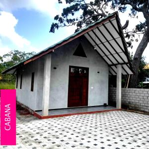 a small white house with a red door at Ari Guest House in Anuradhapura