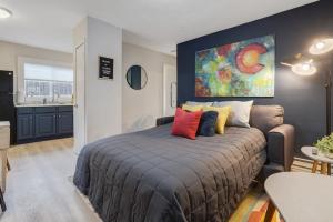 a bedroom with a large bed and a kitchen at Bonny Creation - Chic Downtown Convenience Hot Tub in Colorado Springs