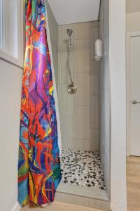 a shower with a colorful shower curtain in a bathroom at Bonny Creation - Chic Downtown Convenience Hot Tub in Colorado Springs