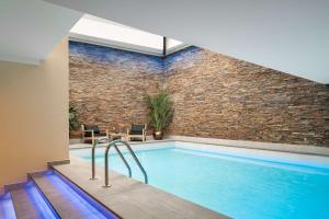 une piscine intérieure avec un mur en briques dans l'établissement art'otel amsterdam, Powered by Radisson Hotels, à Amsterdam