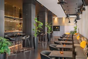 un restaurant avec des tables, des chaises et des plantes dans l'établissement art'otel amsterdam, Powered by Radisson Hotels, à Amsterdam