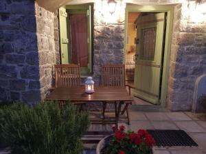 - une table en bois avec 2 chaises sur la terrasse dans l'établissement Likno, à Avgonyma