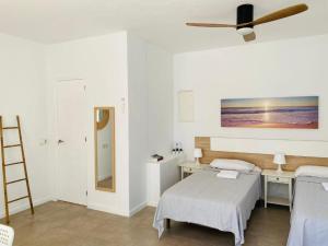 a bedroom with a bed and a ceiling fan at Apartamentos Cana Sofía in Cala Llonga +33 photos