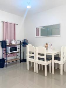 a dining room with a white table and chairs at Transient House Orani in Orani