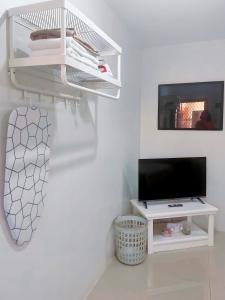 a white room with a tv and a white shelf at Transient House Orani in Orani