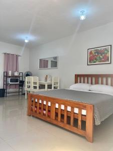 een slaapkamer met een bed en een tafel en stoelen bij Transient House Orani in Orani