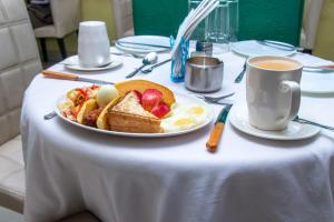 a table with a plate of food and a cup of coffee at Epitome Times Hotel in Nairobi