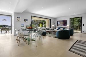 a dining room and living room with a table and chairs at villa 250 m² Vue mer Luxe parking in Grimaud