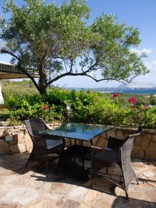 聖特奧多羅的住宿－Villa Minda，桌椅,树和鲜花