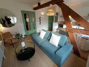 salon z niebieską kanapą i stołem w obiekcie Le Cactus - Gare w mieście Angers