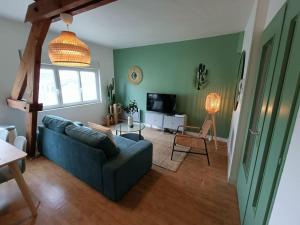 sala de estar con sofá azul y TV en Le Cactus - Gare, en Angers