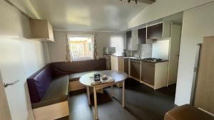 a small apartment with a couch and a table at Camping la Nouvelle Aventure in Audincthum