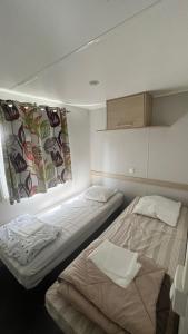 a room with two beds and a cabinet in it at Camping la Nouvelle Aventure in Audincthum