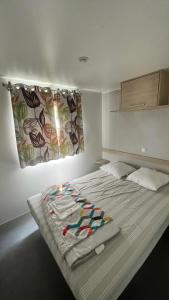 a bedroom with a bed with a blanket on it at Camping la Nouvelle Aventure in Audincthum