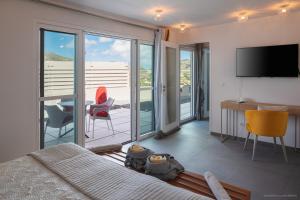 sypialnia z łóżkiem oraz balkon ze stołem i krzesłami w obiekcie Luxury Vacation Villa 15 w mieście Saint Barthelemy