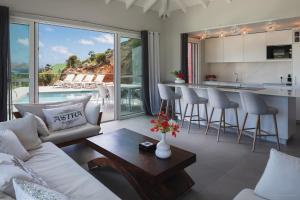 ein Wohnzimmer mit einem Sofa und einem Tisch sowie eine Küche in der Unterkunft Luxury Vacation Villa 15 in Saint Barthelemy