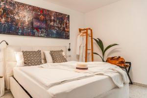 a bedroom with a white bed with a hat on it at Koper Seaside Residence in Koper