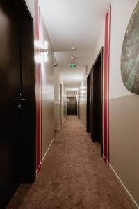 un pasillo en un hotel con un largo pasillo en Hotel-Restaurant La Caborne, en Limonest