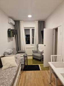 a small living room with a bed and a table at Nest in Sajmište
