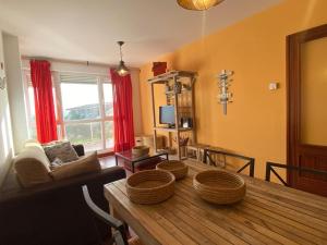 Una sala de estar con una mesa de madera con cestas encima. en Los caballos beach apartment, en Cuchía