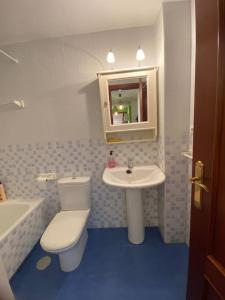 Un baño con un inodoro blanco y un lavabo. en Los caballos beach apartment, en Cuchía 14 fotos más