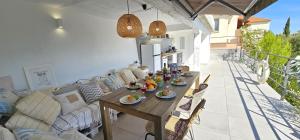 a wooden table with plates of food on a patio at Jacuzzi, summer kitchen, gardens, 20m to beach - Villa Casa Plaza in Seget Vranjica +45 photos