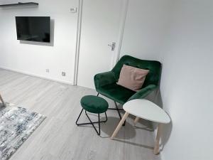 倫敦的住宿－3 Bedroom Flat Haggerston, Hackney, London，一个带枕头和凳子的绿椅