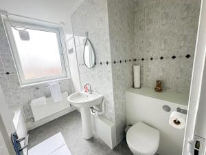 倫敦的住宿－3 Bedroom Flat Haggerston, Hackney, London，白色的浴室设有水槽和卫生间。
