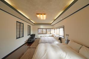 two beds in a room with two windows at Kyo-machiya Stay WAKA Fushimiinari in Kyoto