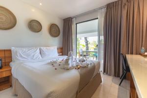 a bedroom with a white bed with flowers on it at Golden Sands Destination Resorts in Daanbantayan