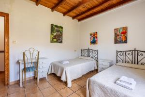 - une chambre avec deux lits, une table et une chaise dans l'établissement Villa Verde, à Nigüelas