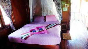 Una cama con un cinturón rosa encima. en Nadia Resort Kohjum en Ko Jum