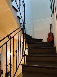 gitara siedzi na schodach domu w obiekcie B&B Acqua di Mare w mieście Bordighera