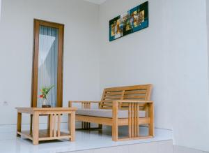 Habitación con banco y 2 mesas en Sriwedari House Keramas, en Gianyar