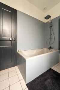 a bath tub in a bathroom with a black door at La maison Janisse - gîte en centre-ville avec jardin in Limoges +24 photos