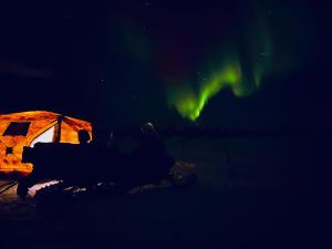 a tent under the aurora in the dark at Aurora Tent Camp in Karasjok