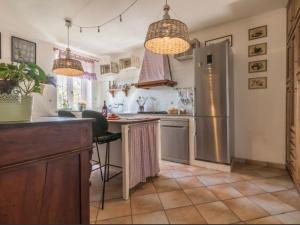 ボルセーナにあるIl Giardino Etrusco Bolsenaのステンレス製の冷蔵庫と2つのシャンデリアを備えたキッチン